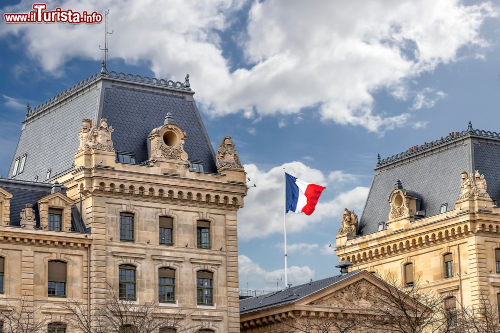 Immagine La bandiera francese sventola sul palazzo della Conciergerie a Parigi, Francia. Assieme alla Sainte-Chapelle, la Conciergerie rappresenta una delle vestigia del più antico palazzo cittadino, il Palais de la Cité voluto da Filippo il Bello all'inizio del XIV° secolo.