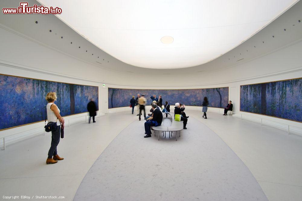 Immagine Visitatori nella sala delle Ninfee al Museo dell'Orangerie di Parigi, Francia. Fu alla fine della prima guerra mondiale che Georges Clémenceau chiese al pittore Monet di realizzare e donare al governo di Francia dei pannelli decorativi: le Nymphéas vennero poi esposte nel 1927 proprio all'Orangerie - © EQRoy / Shutterstock.com