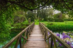 Un ponte in legno immerso nella vegetazione del Giardino di Ninfa, Cisterna di Latina (Lazio) - © ValerioMei / Shutterstock.com
