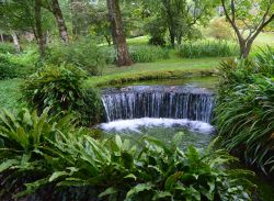 Una piccola cascata al Giardino di Ninfa a Cisterna di Latina, Lazio. Nel 2000 la Regione Lazio ha dichiarato questo giardino monumento naturale per tutelare l'habitat cosstituito dal fiume ...