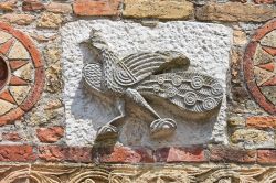 Scorcio del muro esterno dell'Abbazia di pomposa: un pavone scolpito su arenaria