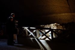 Visitatori al cimitero delle Fontanelle di Napoli, Campania:  è scavato nella roccia tufacea gialla della collina di Materdei - © Francesca Sciarra / Shutterstock.com