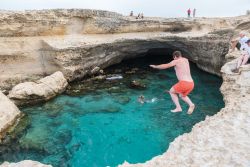I tuffi spericolati da una altezza di 5 metri dentro alla Grotta della Poesia di Melendugno in Salento (Puglia) - © Dziurek / Shutterstock.com