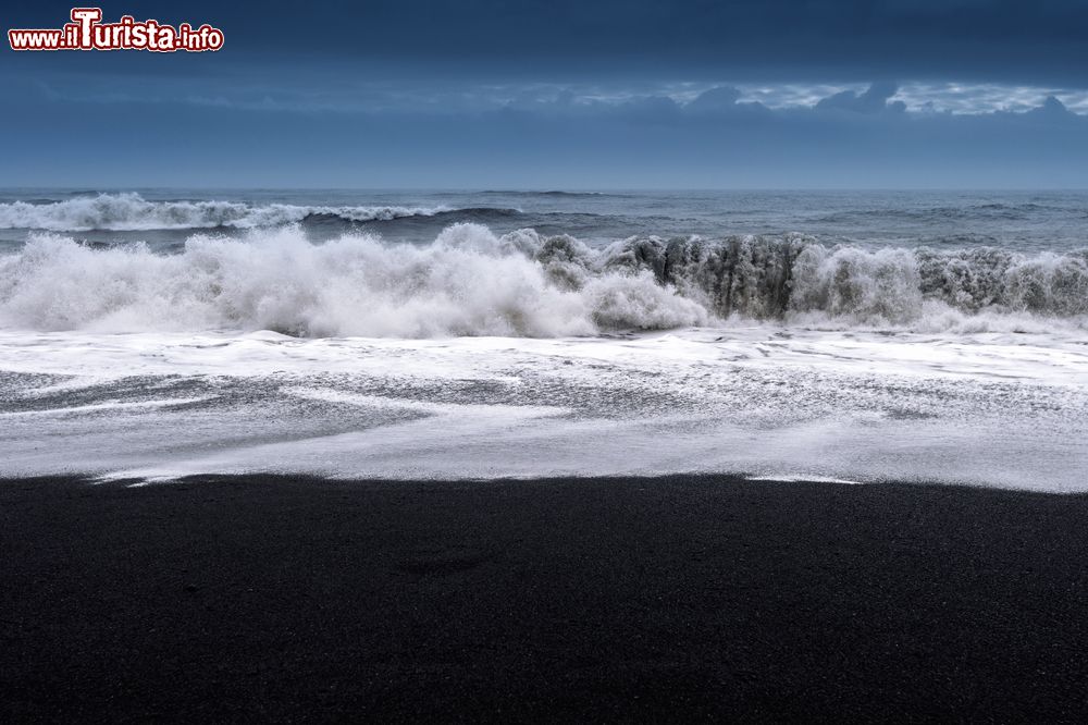 Immagine Il mare impetuoso si abbatte sulla sabbia nera della spiaggia ai piedi del promontorio di Dyrholaey (Vik, Islanda).