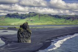 Un faraglione di basalto sulla spiaggia vulcanica tra Vik e il promontorio di Dyrhólaey, in Islanda.
