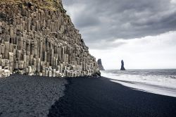 La spiaggia di sabbia nera di Reynisfjara e le colonne di basalto ai piedi del Monte Reynisfjall, tra Vik e il promontorio di Dyrholaey (Islanda).