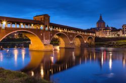 Pittoresco panorama al tramonto con il Ponte Coperto di Pavia, Lombardia. Costruito fra il 1949 e il 1951, questo ponte ripropone le forme di quello antico del XIV° secolo. 

