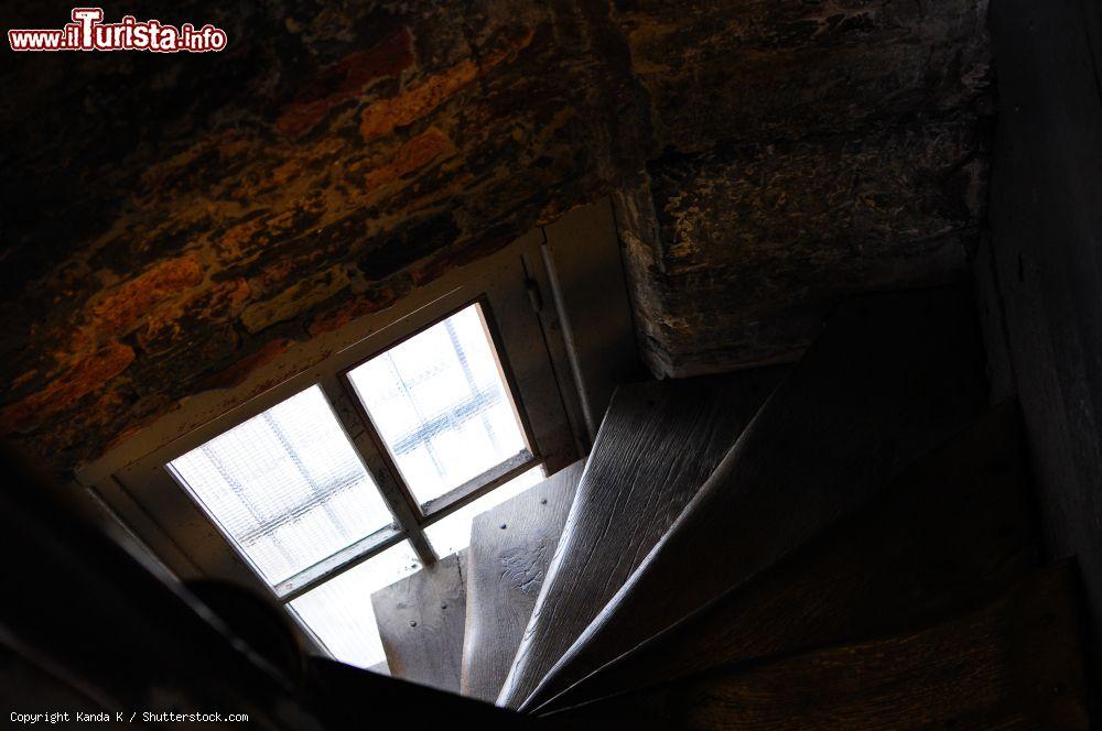 Immagine Interno della torre civica di Bruges, Belgio: particolare delle ripide scale in legno e del muro in mattoni - © Kanda K / Shutterstock.com