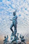 Un cielo a pecorelle incornicia la Statua del Nettuno in centro a Bologna