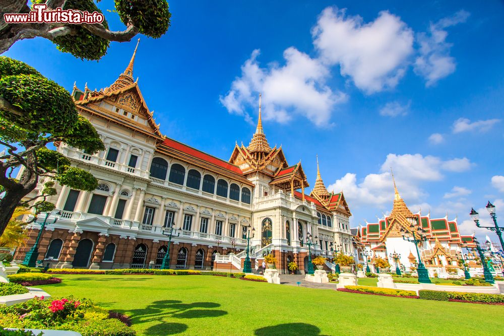 Immagine Il suggestivo Gran Palazzo Reale di Bangkok, Thailandia, in una giornata con il cielo azzurro. Per visitare il luogo sacro è necessario un abbigliamento adeguato che copra gambe e spalle.
