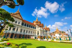 Il suggestivo Gran Palazzo Reale di Bangkok, Thailandia, in una giornata con il cielo azzurro. Per visitare il luogo sacro è necessario un abbigliamento adeguato che copra gambe e spalle.
 ...