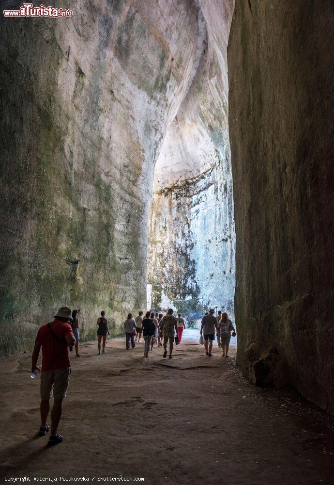 Immagine Orecchio di Dioniso, Siracusa: turisti provano l'acustica della grotta del parco archeologico della Neapolis - © Valerija Polakovska / Shutterstock.com
