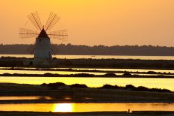 Il tramonto magico alle Saline di Marsala in Sicilia: uno dei mulini dello Stagnone