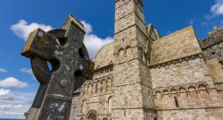 Particolare di una croce celtica in pietra e il complesso di Rock of Cashel in Irlanda