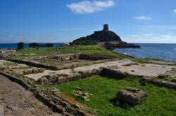 La cosiddetta "Fullonica" di Nora e, sullo sfondo, la Torre del Coltellazzo all'estremità del Capo di Pula.
