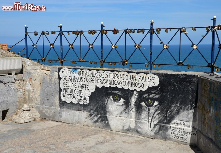 Belvedere di  Peschici, il borgo sul Gargano (Puglia) -  Il promontorio del Gargano è già un luogo romantico per eccellenza, con i suoi borghi arroccati, il verde delle foreste ed il suo mare ricco di calette e belle spiagge. I veri innamorati si recano però nel centro storico di Peschici, lungo la costa nord del promontorio, dove in prossimità del castello, nella parte alta del borgo, si apre un magnifico belvedere. Davanti al blu dell'Adriatico e la vista mozzafiato della costa, tra i murales e gli immancabili lucchetti ispirati dal Ponte Milvio, sono molte le coppie che vengono qui a giurarsi eterno amore, davanti all'immensità del mare - © honorius77 / Shutterstock.com