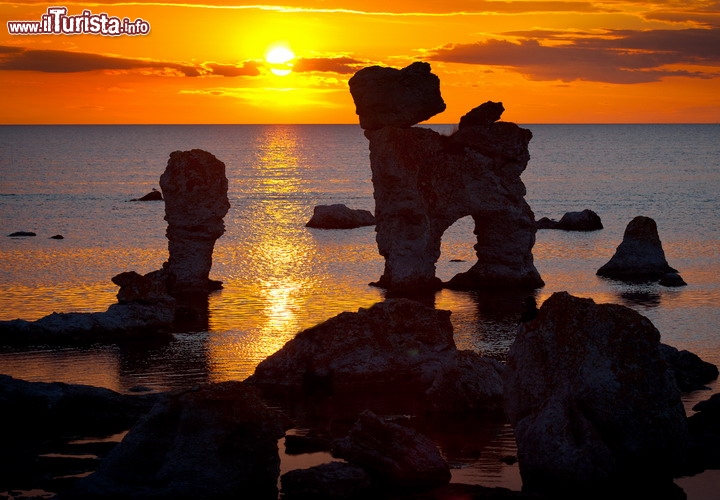 Faraglioni dell'isola di Faro, a nord di Gotland, in Svezia - A detta di molti è il luogo più bello per ammirare un tramonto in terrirorio svedese: l'isola di Fårö si trova in mezzo al mar Baltico, appena a nord della più grande isola di Gotland. Le rocce calcaree della sua costa occidentale sono state erose in modo spettacolare, creando dei faraglioni che qui vengono chiamati Raukar. Ce ne sono di antropomorfi, altri che hanno forme che ricordano quelle di animali, e che creano un effetto straordinario al tramonto, quando vengono ammirati in controluce. Questo sito era particolarmente amato dal regista Ingmar Bergman che sull'isola di Fårö realizzò ben 6 film: sull'isola trovate un Bergman Center ed ogni anno a giugno, il mese più bello per ammirare il tramonto da questo luogo romantico, si svolge il festival Bergmanveckan (la settimana di Bergman) che celebra il grande regista svedese - © Bildvision AB / Shutterstock.com