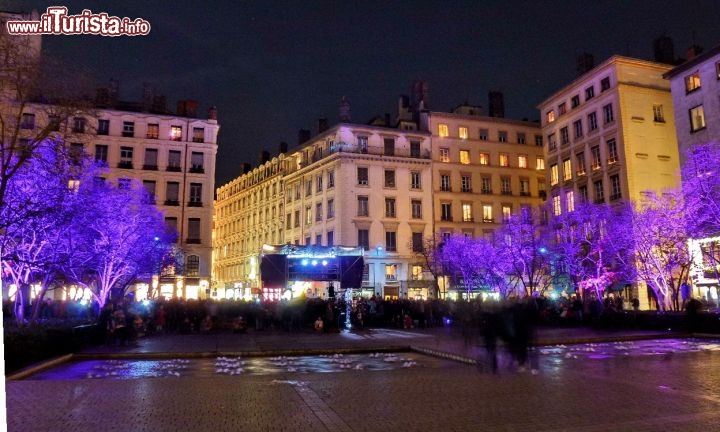 Alberi illuminati con folla in strada