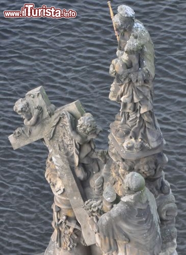 Praga in inverno: una statua sul Ponte Carlo, con lo sfondo della Moldava