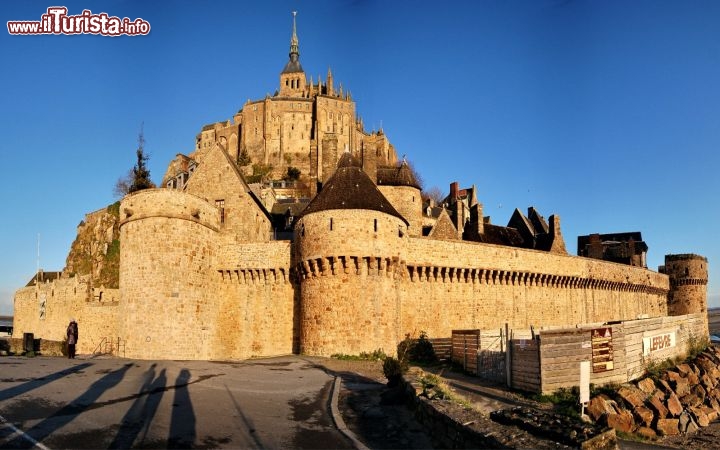 Nella luce radente della mattina Mont Saint michel appare nella sua duplice natura di castello e abbazia