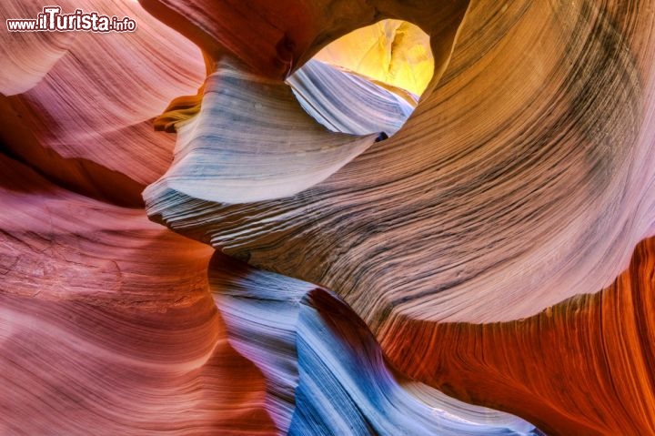 Antelope Canyon, Arizona (USA) - Le arenarie scolpite dall'acqua, ed in parte dal vento, del Canyon dell'Antilope (Antelope), sono un must per ogni viaggiatore. Qui, non distante dalla città di Page, nel nord dell'Arizona, troviamo questo parco naturale, proprietà degli indiani Navajo. E' stato reso visitabile nel 1997 e consiste in due tronconi separati tra loro: l'Upper Canyon ed il lower Antelope Canyon. Quest'ultimo si trova più in profondità ed è forse più spettacolare, ma la sua visita è più faticosa e richiede un tempo meteorologico stabile, dato che il canyon inferiore è più vulnerabile alle piene improvvise del torrente. il canyon è così stretto che la luce del sole arriva solo verso mezzogiorno, sotto forma di isolati e spettacolari raggi  - © Doug Meek / Shutterstock.com