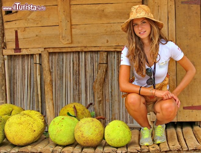 Michela posa a fianco a degli enormi frutti malgasci