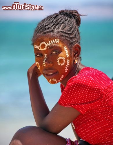 Ragazza malgascia con maschera protettiva e decorazioni