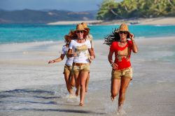 Le ragazze corrono su una spiaggia di Nosy Iranja ...