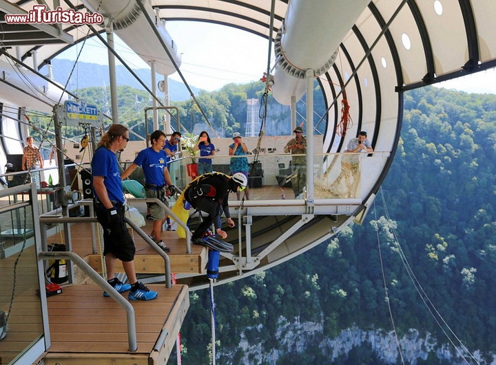 Bungee jumping dallo SkyBridge di Sochi, Russia - In fotografia vedete la piattaforma di lancio per il bungee jumping, posta a 207 m di altezza sulla valle. Il ponte pedonale più lungo del mondo è così grande e robusto che potrebbe ospitare fino a 30.000 persone contemporaneamente! L'enorme passerella è stata costruito ad est della città di Sochi, tra le montagne del Grande Caucaso che hanno accolto l'ultima  edizione dei Giochi Olimpici d'inverno. La valle scelta per l'installazione dello SkyBridge è stata quella della città di Krasnaya Polyana, nel Territorio di Krasnodar - © europics