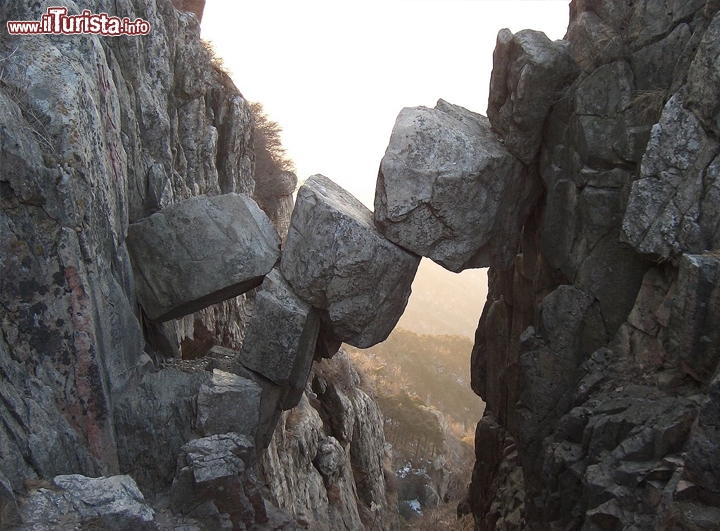 Monte Tai, il Ponte degli Immortali in Cina - Strani picchi di granito formano un paesaggio incredibile, con spaccature nelle rocce e precipizi dalle notevoli altezze. Il luogo si trova nella catena di Huangsang, le montagne gialle dell'Asia orientale ed è davvero un posto che ogni viaggiatore dovrebbe visitare, almeno una volta nella vita. Non ha caso è Patrimonio dell'Umanità UNESCO. Si tratta di una delle 5 montagne sacre cinesi. Qui si trova il famoso Ponte degli Immortali, sia in versione naturale che architettonica, considerato il più alto del mondo. Da non perdere l'escursione fino alla "Porta del Sud celeste", che si svolge su 3 assi scricchiolanti a sbalzo su una voragine, su cui potete muovervi reggendovi con una catena di ferro. Se avete paura dell'altezza, e soffrite di vertigini, probabilmente questi luoghi non fanno per voi, anche perchè rischiate di screditare il nome del ponte! Però il panorama visto da qui, all'alba, vale da solo tutto il viaggio in Cina.