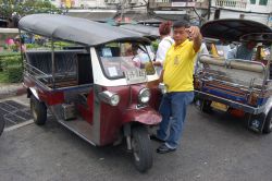 Un tuk tuk invita ad un tour di Bangkok