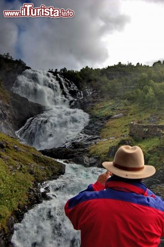 Un turista ammira la fragorosa cascata Kjosfossen
