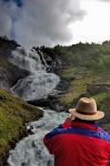 Un turista ammira la fragorosa cascata Kjosfossen ...