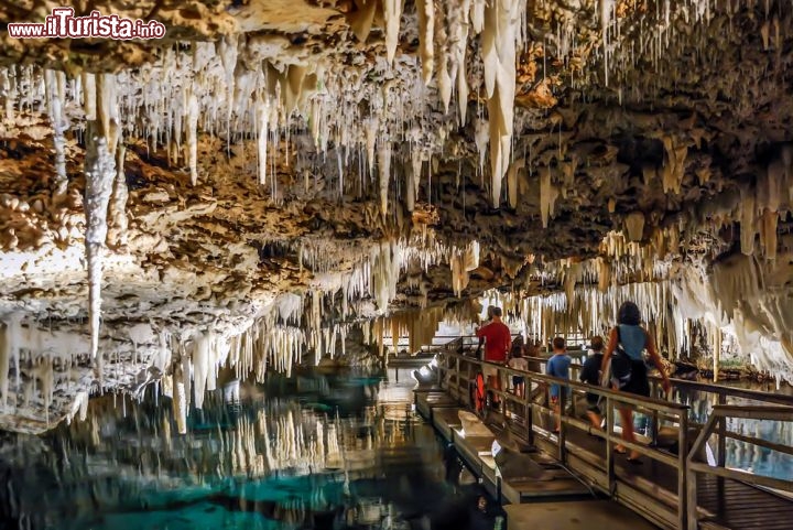 Crystal e Fantasy Cave. Bermuda - Non lontano dalla città di St George's, Cristal Cave e Fantasy Cave sono tra le grotte più affascinanti del mondo: la prima lunga circa mezzo chilometro, raggiunge una profondità massima di 62 metri, con il fondo che rimane ricoperto dalle acque marine. La seconda grotta, Fantasy Cave, presenta la stalattiti meglio conservate. La grotta si formò durante un periodo freddo (glaciazione), con le acque marine che, ritirandosi, lasciarono esposte le rocce calcaree alle piogge meteoriche, creando queste spettacolari forme di erosione. Poi il mare recuperò parte del suo livello, sommergendo parzialmente le cavità carsiche.
La grotta di Crystal Cave venne scoperta nel 1905 e da allora è divunuta una delle attrezioni più importanti delle Isole Bermuda. La visita permette di ammirare le bellissime concrezioni e soprattutto un gran numero di luccicanti minerali, specie in Fantasy Cave, la seconda grotta del complesso, scoperta successivamente e meno danneggiata. Nota de il Turista: le stalattiti sarebbero anche visibili in modo più spettacolare con una immersione dentro ai laghetti delle due grotte, ma sono da richiedere dei permessi speciali, per oggettivi motivi scientifici   - © Russ Hamilton / Shutterstock.com