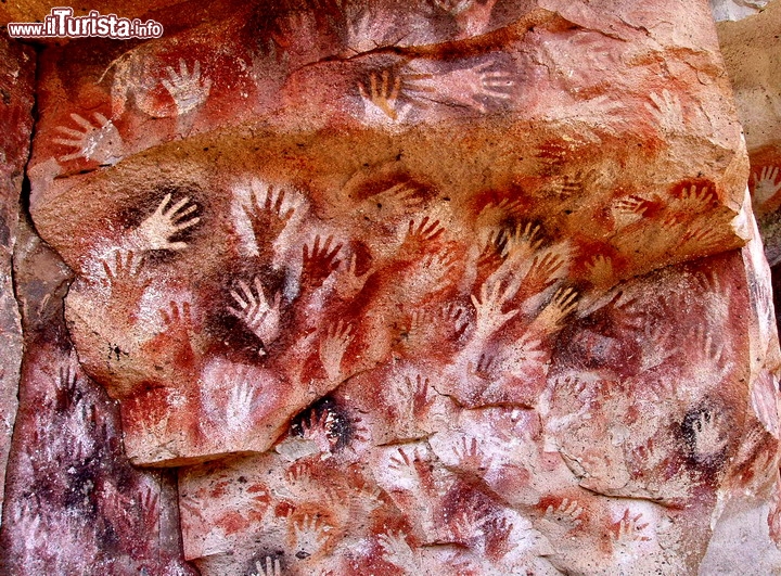 Cueva de las Manos, Argentina - Questa magnifica caverna si trova nella valle del Rio Pinturas, e il suo nome la dice lunga sulla caratteristica di questa asta fluviale: circa 10.000 anni fa le popolazioni di questa porzione della Patagonia. lasciarono numerose testimonianze della loro presenza sotto forma di graffiti, disegni e questa particolare parete. Appoggiando le mani alla roccia e soffiando forse con la bocca i pigmenti posizionati dentro a delle ossa, ne è risultato un effetto straordinario che ancora oggi affascina i visitatori che giungono in questa zona remota. Forse le mani rappresentano il risultato "fossile" un rito di ingresso dei giovani della tribù, nella vita adulta. Ci troviamo nel territorio del Parco Nazionale Perito Moreno ed il sito è Patrimonio dell'Umanità dell'UNESCO    Cortesia foto Mariano su wikipedia