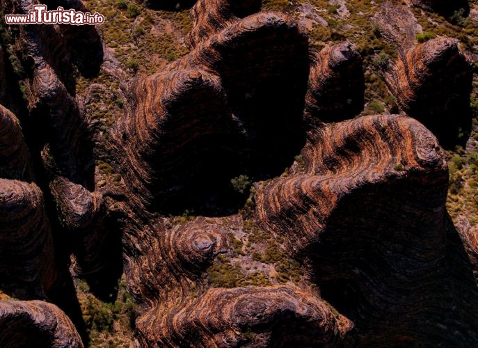 Luci ed ombre tra i Bungle Bungle Australia. Viste da vicino le rocce appiano nella loro stranezza di essere stratificate con livelli neri ed arancioni. Un eventuale escursionista potrebbe rovinare la superficie delle rocce innescando una accellerazione dei processi erosivi.