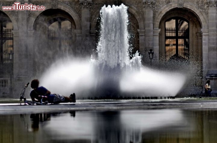 Immagine Ciclista si riposa alla fontana davanti Museo del Louvre