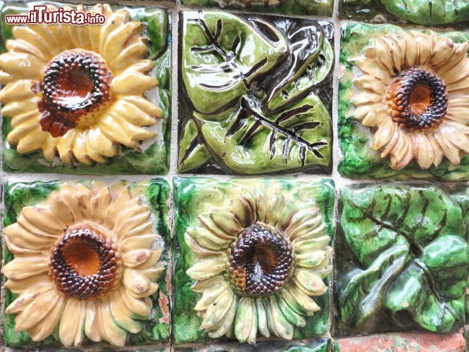 Dettaglio de El Capricho de Gaudì - le ceramiche dell'esterno danno un tocco di lucentezza e vivacità all'edificio. Notare il tema a foglie e a girasoli. Quest'ultimi ricordano che il progetto di Gaudì prevedeva un perfettamento orientamento della villa con il sole, in modo che l'utilizzo degli ambienti sia ottimizzato al livello di illuminazione naturale.