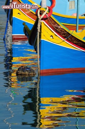 Luzzu, la barca tradizionale dei pescatori di Malta - Queste coloratissime imbarcazioni colpiscono moltissimo i turisti, specialmente quando nelle acque calme del porto i riflessi delle barche creano magiche simmetrie. La loro origine porebbe essere riferita ai Fenici, dato che i navigatori libanesi nabigarano per tutto il bacino del Mediterraeo, e come le antiche barche di questo popolo sulla prua vengono dipinti due occhi, detti gli occhi di Osiride.