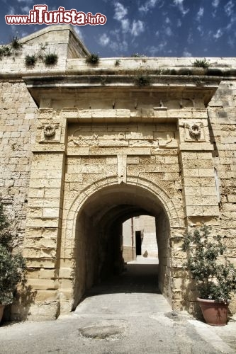 Porta accesso centro storico isola Malta - Trovandosi sul crocevia di Rotte commerciali e militari, Malta da sempre ha avuto una vita intensa, ma rischiosa, a causa delle scorribande di pirati, saraceni, ed eserciti di varie nazionalità. Non sorprende quindi di trovare le città storiche protette da poderose cinte murarie in pietra, da cui si accedeva nei centri storici attraverso eleganti porte di ingresso