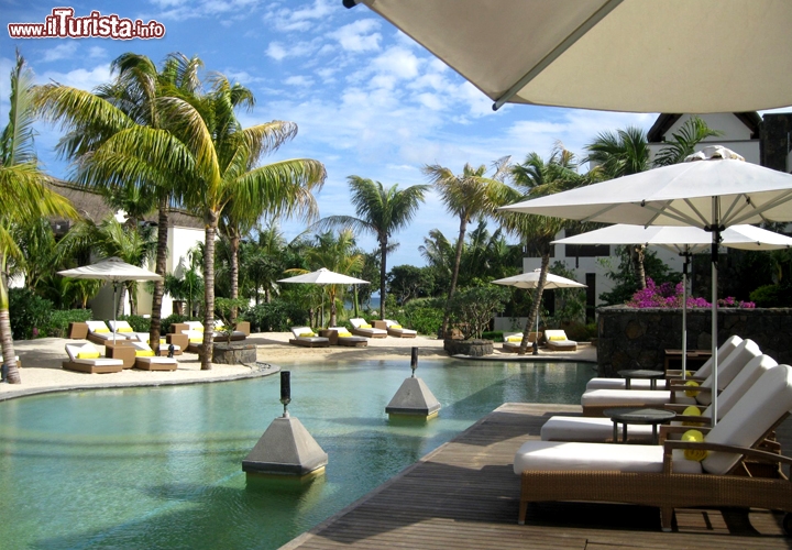 La piscina dell'Angsana Balaclava raddoppia la bellezza del resort, riflettendo il turchese del cielo e la sagoma delle palme.