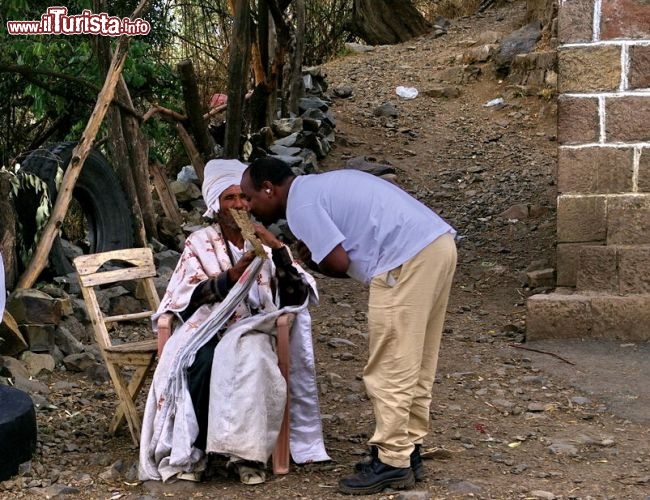 Rotta storica una guida bacia la Croce in segno di devozione - In Etiopia con i Viaggi di Maurizio Levi
