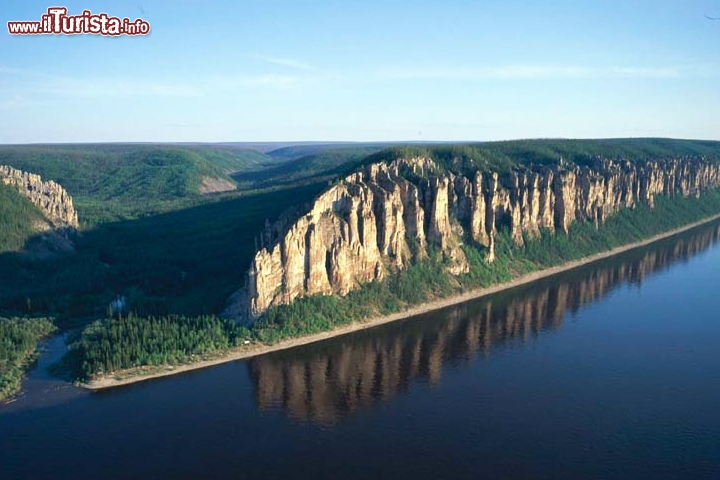 Lena Pillars Nature Park – Russia - UNESCO
Il parco naturale si estende lungo le rive del fiume Lena nella zona più orientale della Siberia (Russia) e deve la propria fama alle sensazionali formazioni rocciose che dominano il territorio, che si trova a meno di un giorno di navigazione verso sud dalla città di Yakutsk, nella Repubblica Autonoma della Sacha-Jacuzia. Le rocce, chiamate “pilastri” per via della loro caratteristica forma, possono raggiungere un'altezza di trecento metri; esse si formarono durante l'Era Cambriana e hanno continuato a modellarsi grazie alle condizioni climatiche estreme della regione, dove le escursioni termiche tra inverno ed estate arrivano addirittura a cento gradi: qui il clima continentale infatti porta con sé temperature di -60° in inverno e di 40° in estate. Le rocce sono separate tra loro da profonde spaccature che danno vita a torrenti d'acqua durante il periodo di disgelo che hanno contribuito nel corso della storia a modellare i pilastri e ad isolarli reciprocamente. 

Foto: © UNESCO
© PENTA Ltd.
Autore: V. Ryabkov