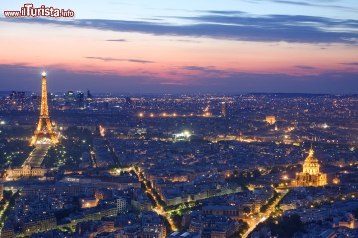 Immagine Vista area di Parigi al tramonto: la Tour Eiffel sulla sinistra, l'Hotel des Invalides in basso a destra e l'Arco di Trionfo in alto a destra  - © unknown1861 / Shutterstock.com