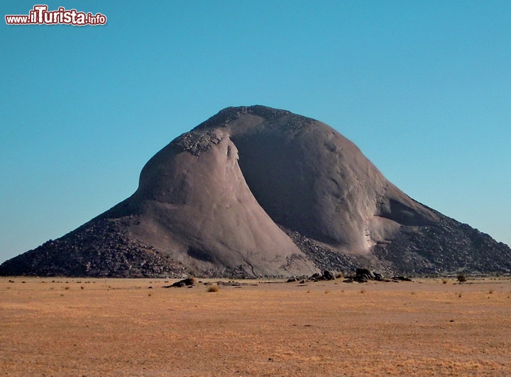 Ben Amera, Mauritania
Se c'è una montagna che possa avere un vero fascino ancestrale, e senza orde di turisti che l'assalgano, forse l'unico luogo è il sito di Ben Amera in Mauritania (o Ben Amira) la terza roccia monolitica del pianeta per grandezza, dopo le due montagne dell'Australia, il Monte Augustus e la celeberrima Ayers Rock, la roccia di Uluru degli aborigeni. E' un unico monolite di roccia di circa 1,5 x 1,8 km ed una altezza massima di circa 380 metri sul piano campagna, 550 metri in totale. Dista circa 300 km dall'oceano, che ci sembra una distanza ragionevole di sicurezza, tenendo conto della quota rialzata rispetto al livello del mare. Qui la mappa interattiva.

