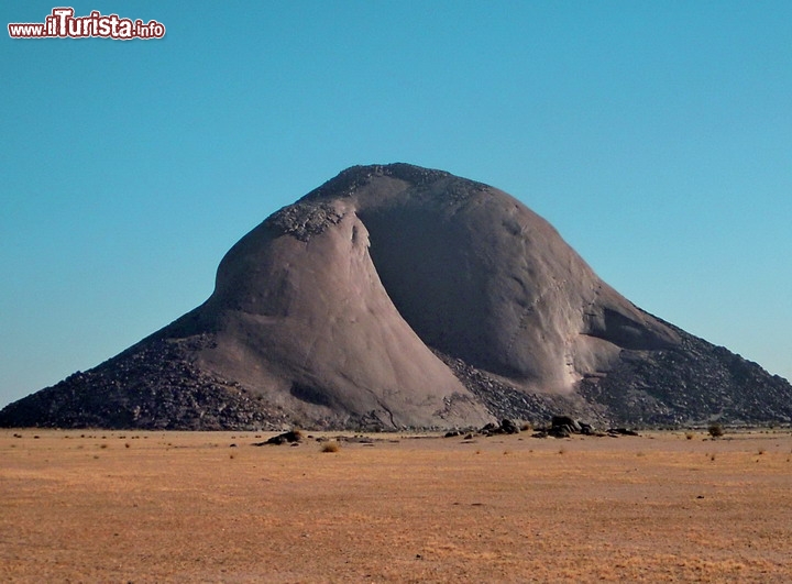 Ben Amera, Mauritania
Se c'è una montagna che possa avere un vero fascino ancestrale, e senza orde di turisti che l'assalgano, forse l'unico luogo è il sito di Ben Amera in Mauritania (o Ben Amira) la terza roccia monolitica del pianeta per grandezza, dopo le due montagne dell'Australia, il Monte Augustus e la celeberrima Ayers Rock, la roccia di Uluru degli aborigeni. E' un unico monolite di roccia di circa 1,5 x 1,8 km ed una altezza massima di circa 380 metri sul piano campagna, 550 metri in totale. Dista circa 300 km dall'oceano, che ci sembra una distanza ragionevole di sicurezza, tenendo conto della quota rialzata rispetto al livello del mare. Qui la mappa interattiva.

