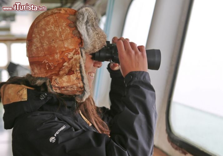 Sara in navigazione, lungo i fiordi della Patagonia Cilena, con un binocola esplora il paesaggio. E' facile imbatersi in animali straordinari, come i delfini, foche e leoni di mare, e le grandi orche e balene - © DONNAVVENTURA® 2012 - Tutti i diritti riservati - All rights reserved