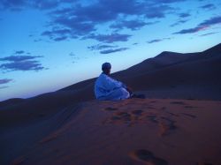 Un Nomade nel deserto di Merzouga contempla le ...