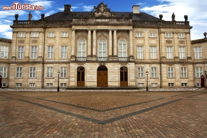 Il Palazzo Amalienborg a Copenaghen, in Danimarca - Si tratta della residenza invernale della famiglia reale danese, e consiste di 4 identici palazzi che si contrappongono sugli angoli della piazza centrale, dove svetta la statua di Federico V di Danimarca. In realtà non doveva trattarsi di un complesso reale, ma a causa di un incendio che coinvolse la residenza di Christiansborg la famiglia reale decise di trasferisi qui, nel 1794. Lo stle rococò si deve all'architetto  Nicolai Eigtved. - © John Gordon / Shutterstock.com

