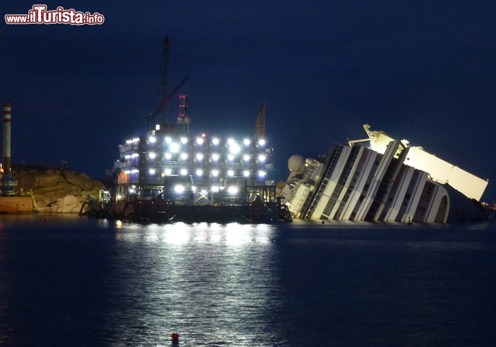 La Costa Concordia illuminata nel porto del Giglio - Nonostante si lavori senza sosta 24 ore su 24 7 giorni su 7 la data di chiusura del cantiere e completamento delle operazioni ha già subito diverse proroghe, essendo prevista inizialmente per il maggio del 2013, a circa un anno di distanza dall’inizio dell’intervento. Tuttavia, ci sono legittime aspettative che il tutto possa essere ultimato tra la fine del 2013 e l’inizio del 2014.